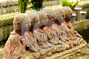 Stone statue of Buddhist monks sitting and praying