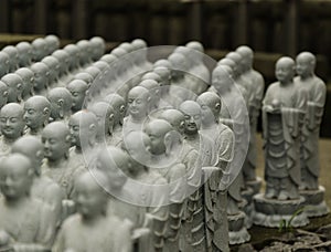 Stone statue of Buddhist monks sitting and praying