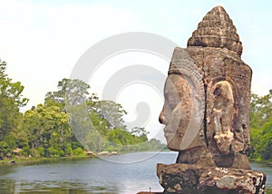 Stone statue Deva at the south gate of Angkor Thom, Angkor Wat. Overlooking the Moat