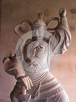 Stone statue of a dharma protector in the temple.