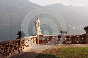 Stone statue on the shores of Lake Como in Italy photo