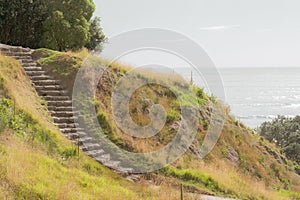 Stone steps down track up Mount Maunganui with view beyond to Pacific Ocean