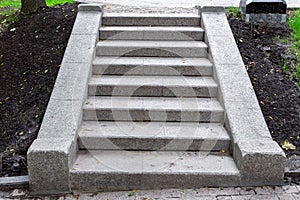 Stone steps of gray granite blocks on a slope.