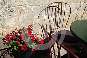 Stone street cafe - multi-colored metal chairs, tables and flowers.