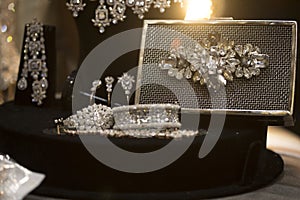 Stone studded platinum bracelet on display with a metal clutch