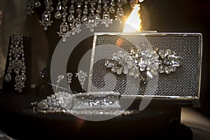 Stone studded platinum bracelet on display with a metal clutch