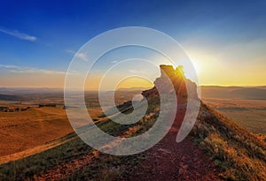 A stone during sunset on the top of a mountain in the Sunduki Park in Khakassia photo