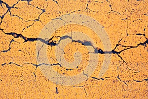 Stone surface with cracks, covered with yellow paint