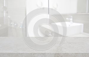 Stone table top and blurred hotel bathroom interior as background