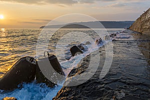 Stone tetrapods on the seashore in which the waves break.