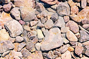 Stone texture background. Close-up of natural sea gravel or pebbles at summer beach with selective focus. Natural design backdrop