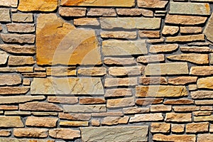 Stone texture background. Closeup of a old gray brown of a weathered concrete wall with a hilly uneven surface with natural stones