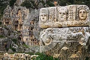 Stone theater faces and masks in Myra Ancient City. Lycian rock tombs in background. Demre, Antalya photo