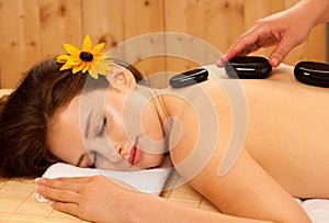 Stone therapy. Woman getting a hot stone massage at spa salon