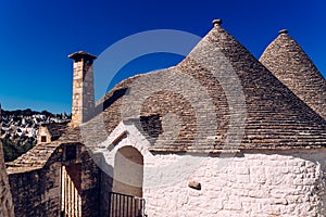 Stone tiles cover the roofs of the trulli in Alberobello, an Italian city to visit on a trip to Italy
