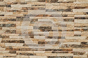 Stone tiles on the wall. The wall is made of ceramic  granite tiles. The structure of the stone.