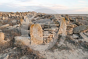 stone tombstones with symbols in desert.