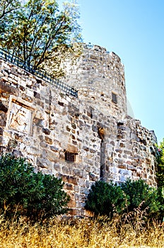 Stone tower and walls of the castle of St. Peter in Bodrum. The earth under the walls was overgrown with grass, dried up under the