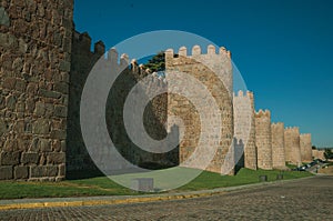 Stone towers on the large city wall next to street at Avila