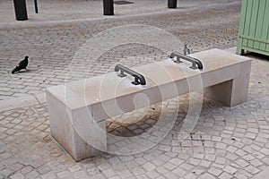 Stone town bench seat with center arm steel rests on hostile design prevents for people homeless from laying down in city center