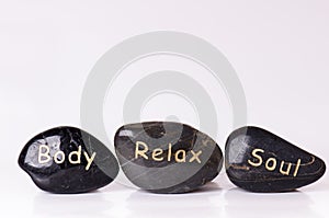 Stone treatment. Black massaging stones on a white background. Hot stones. Balance. Zen like concepts. Basalt stones.