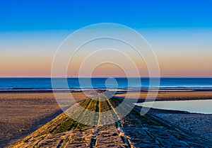 Stone walking or rocks leading into the ocean, beautiful and colorful sky at sunset, Blankenberge beach, Belgium