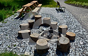 Stone walkways through a nature park made of irregular pieces. There are scabs on the pavement and around there are logs on which