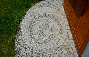 Stone walkways through a nature park made of irregular pieces. There are scabs on the pavement and around there are logs on which