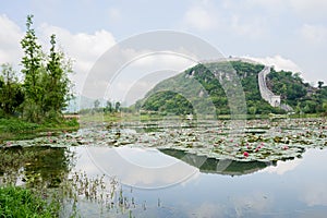 Stone wall with battlements on lakeside hill in sunny spring