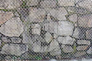 Stone Wall Behind a Wire Fence