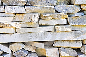Stone wall built with blocks and marble slabs simply placed over
