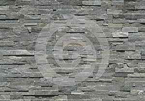 Stone wall cladding made of horizontal gray shades strips of rock . photo
