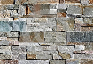 Stone wall cladding made of natural rocks bricks with different sizes and colors photo