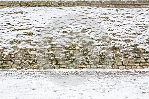 Stone wall covered with snow