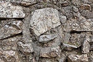 Stone wall folded from solid cobblestone gray and weathered background base