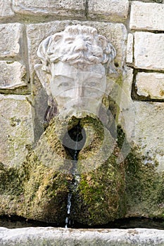 Stone wall fountain with green moss