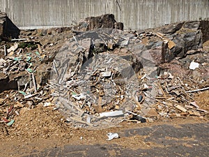 a stone wall in a garbage dump. wooden waste in a landfill.