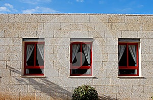 Stone wall of the house with three windows
