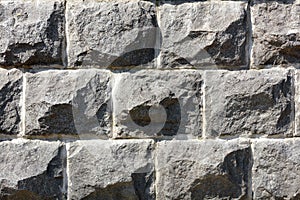 Stone wall of large cobblestone of gray granite, closeup