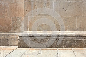 Stone wall with molding and floor background in sunlight, nobody