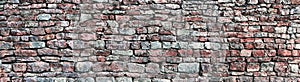 Stone wall panorama, panoramic stonewall pattern background, old aged weathered red and grey grunge limestone dolomite texture