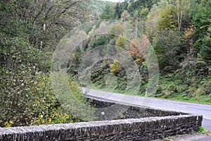 stone wall between a road and a river