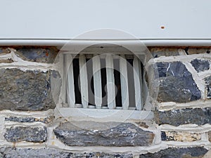 Stone wall with small window with bars