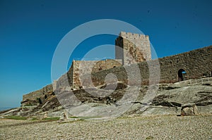 Stone wall and square tower from castle over rocky hill