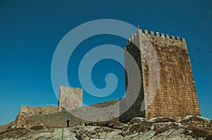 Stone wall and square tower from castle over rocky hill