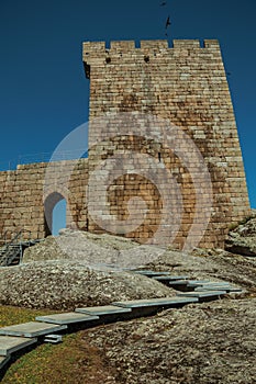 Stone wall and square tower from castle over rocky hill