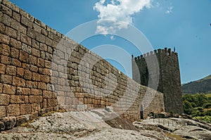 Stone wall and square tower from castle over rocky hill