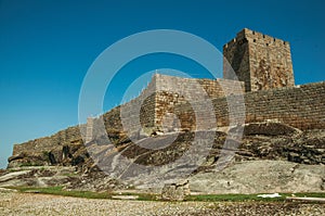 Stone wall and square tower from castle over rocky hill