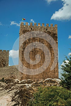 Stone wall and square tower from castle over rocky hill