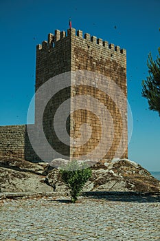 Stone wall and square tower from castle over rocky hill